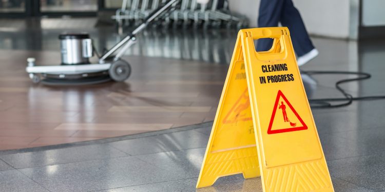 Woman worker cleaning the floor with polishing machine